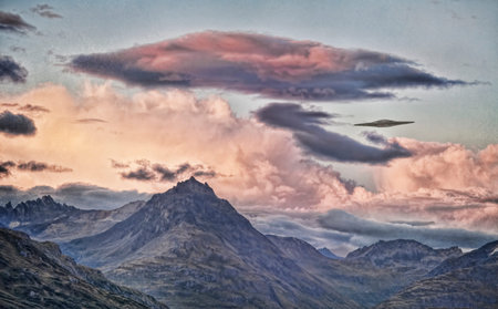 UFO flying saucer over  mountains with sunset clouds processed with textures for an artistic look.の写真素材