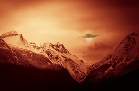 UFO hovering over snow covered mountain peaks with a red glow in the sky.