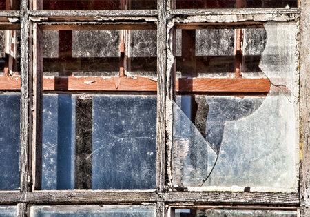 Old broken windows from an abandoned building in daylight.
