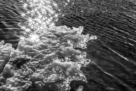Sparkles on sea water and melting ice in Alaska in black and white.の写真素材