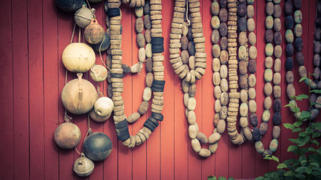 Collection of vintage fishing floats hung on a red wall with vintage coloration.