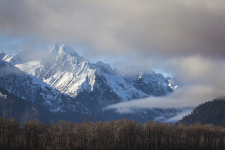 Fog and low clouds clearing to reveal the Chilkat Mountains near Haines, Alaska.の写真素材