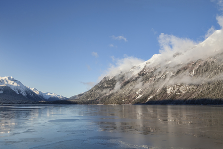 Fog clearning on a sunny winter day in the Lutak Inlet near Haines Alaska.の写真素材