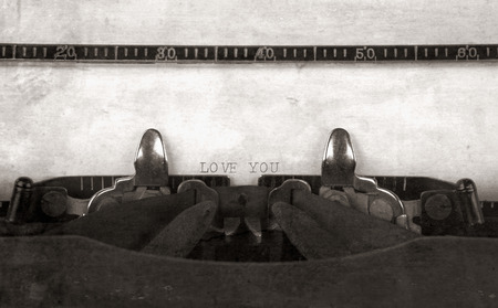 'LOVE YOU' typed on a vintage antique typewriter with an old fashioned look in monochrome.の写真素材