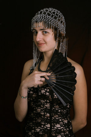 pretty young lady  in old time ball dress with black fanStanding girl with a  fan dress in  style...