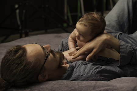 Father holding his three mounts old babyの写真素材