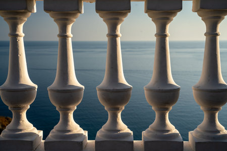 Classic balustrade on the embankment against the sea. White balcony over the sea. Promenade with a...