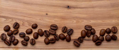 Coffee beans on a wooden background banner, place for the inscription.の写真素材