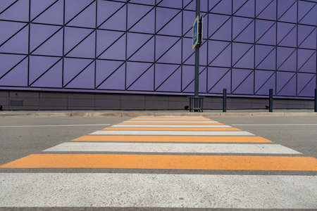 Pedestrian crosswalk on a renovated paved road, to the beginning of the shopping complex. Pedestrian crosswalk on the street for safety, white and yellow stripes.の写真素材