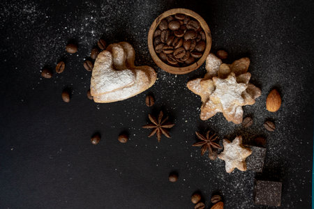 black background with homemade cakes, fragrant cookies. Cookies in the form of hearts, stars, coffee beans, spices, almonds close-up. the concept of the menu. Full sizeの写真素材