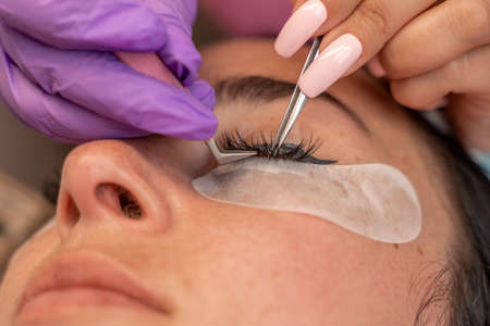 Eyelash extension procedure. Woman eye with long eyelashes. lashes, close up, macro, selective focus.の写真素材