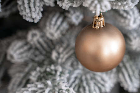 Close-up of a festively decorated outdoor Christmas tree with balls on a blurred sparkling fairy background. Defocused garland lights, bokeh effect.の写真素材