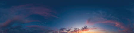 Blue evening sky seamless panorama spherical equirectangular 360 degree view with Cumulus clouds, setting sun. Full zenith for use in 3D graphics, game and aerial drone panoramas as sky replacement.の写真素材