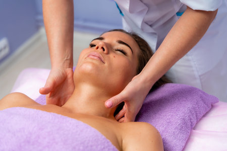 Relaxing massage. European woman getting facial massage in spa salon, side view