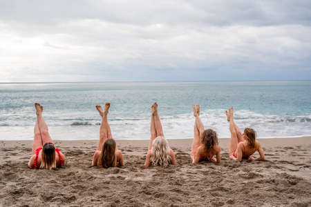 Big happy family or group of five friends is having fun against sunset beach. Beach holidays concept.の写真素材