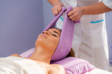 Relaxing massage. European woman getting head massage in spa salon, side viewの写真素材