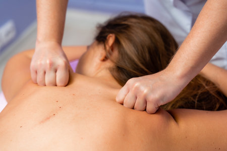 Top view of hands massaging female abdomen.Therapist applying pressure on belly. Woman receiving massage at spa salonの写真素材