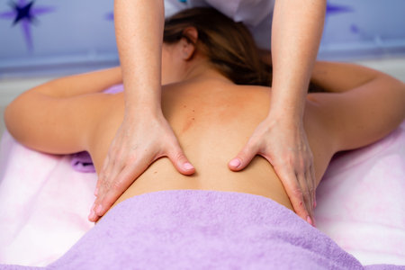 Top view of hands massaging female abdomen.Therapist applying pressure on belly. Woman receiving massage at spa salonの写真素材