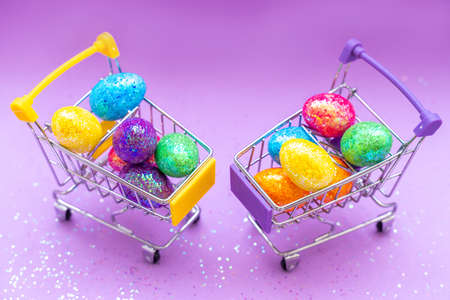 Happy Easter background. Easter eggs are colorful in a shopping basket on purple paper. Holiday concept. Copy space for text.の写真素材
