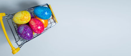 Happy Easter background. Easter colorful eggs in a shopping basket on a white background. Holiday concept. Copy space for text.の写真素材