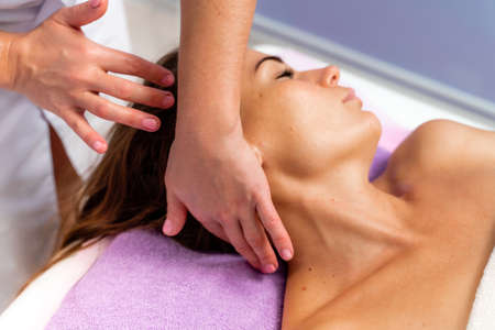 Facial massage. A woman is given a massage in a beauty salon. Close-up.の写真素材
