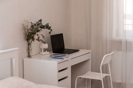White desktop with laptop for remote work or study. Office computer workplace in home interiorの写真素材