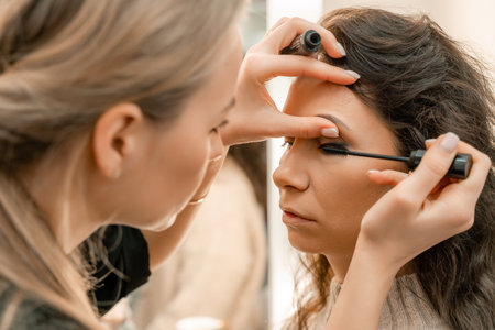 Make-up artist makes a professional make-up of a young woman in the studio.の写真素材