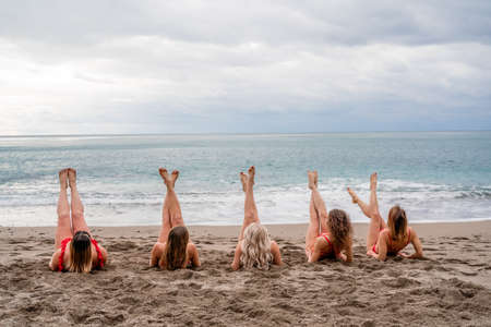 Big happy family or group of five friends is having fun against sunset beach. Beach holidays concept.の写真素材