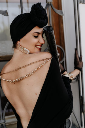 Stylish woman in the city. Fashion photo of a beautiful model in an elegant black dress posing...