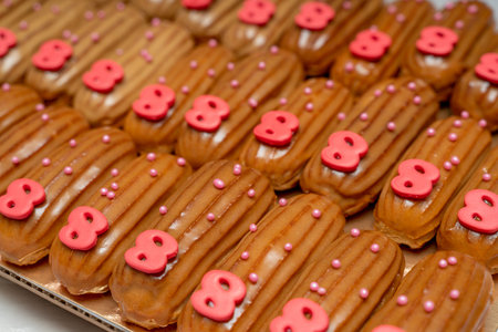 Fresh eclairs with pink number eight and custard lie on the table, background.
