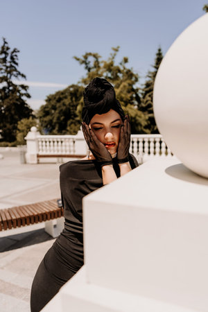 Stylish woman in the city. Fashion photo of a beautiful model in an elegant black dress posing...