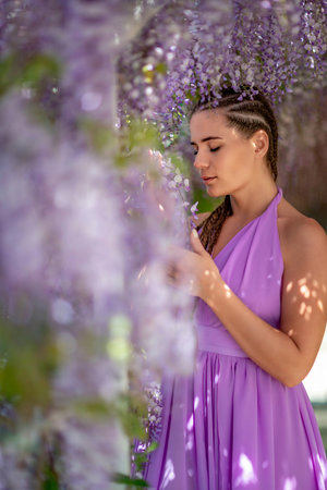 Woman wisteria lilac dress. Thoughtful happy mature woman in purの写真素材