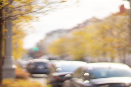Autumn season bokeh background. Abstract city blur along the road with cars.の写真素材