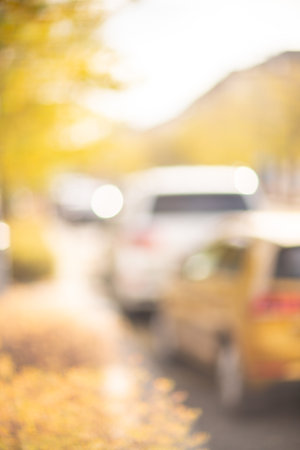 Autumn season bokeh background. Abstract city blur along the road with cars.の写真素材