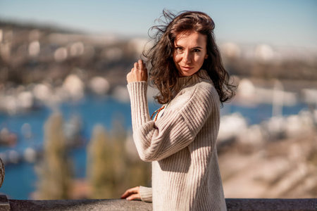 Woman walks in the city, lifestyle. Young beautiful woman in a loose light sweater, brown skirt and...