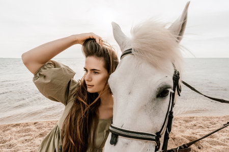 Happy woman and a white horse against the background of the sky and the sea.の写真素材