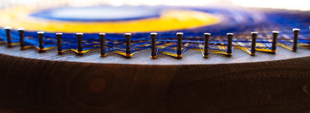 Colored thread mandala on a wooden board with nails. Mandala Moon Harmony Sun esotericism and psychology pictures from yellow and blue silk threads.の写真素材
