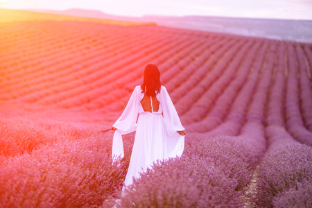 Lavender field happy woman in white dress in lavender field summer time at sunsetの写真素材