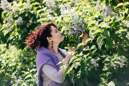 Woman lilac. Portrait of an happy woman surrounded by lilac bushes. Spring seasonal photos.の写真素材
