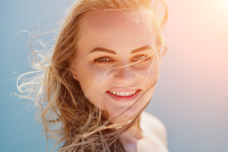 Portrait of a blond woman at the sea, a woman makes photos for memory from a trip to the sea to show to friends.の写真素材