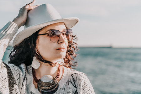 Portrait of a curly haired woman in a white hat and glasses on tの写真素材