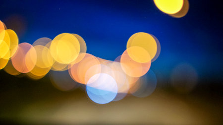 Blurred lights evening city traffic bokeh. Defocused night city traffic. Blurred lights bokeh car headlights driving evening city road. City night traffic backgroundの写真素材