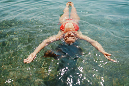 Happy woman sea relaxing floating in transparent sea water on summer holiday. Travel leisure...