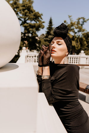 Stylish woman in the city. Fashion photo of a beautiful model in an elegant black dress posing...