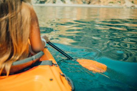 Kayak paddle sea vacation. Person paddles with orange paddle oar on kayak in sea. Leisure active lifestyle recreation activity rest tourism travelの写真素材