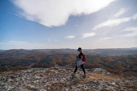 woman backpack on mountain peak looking in beautiful mountain valley in autumn. Landscape with...