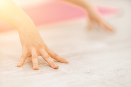 Girl does yoga. Young woman practices asanas on a beige one-ton background.