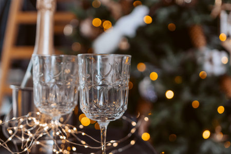 Champagne glasses, New Year decor. New Years festive setting, family holidays.Two glasses of champagne are on the table against the background of New Years decorated tree.の写真素材