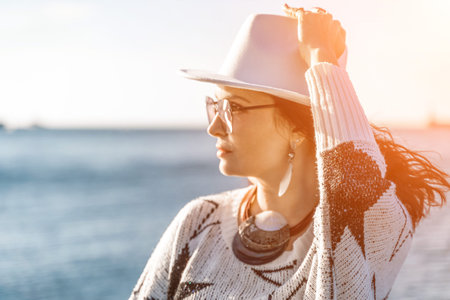 Portrait of a curly haired woman in a white hat and glasses on t