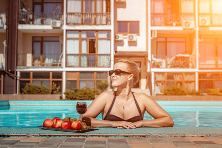 Bikini-clad woman enjoys poolside relaxation. Poolside ambiance. Capturing womans relaxed time near pool.の写真素材